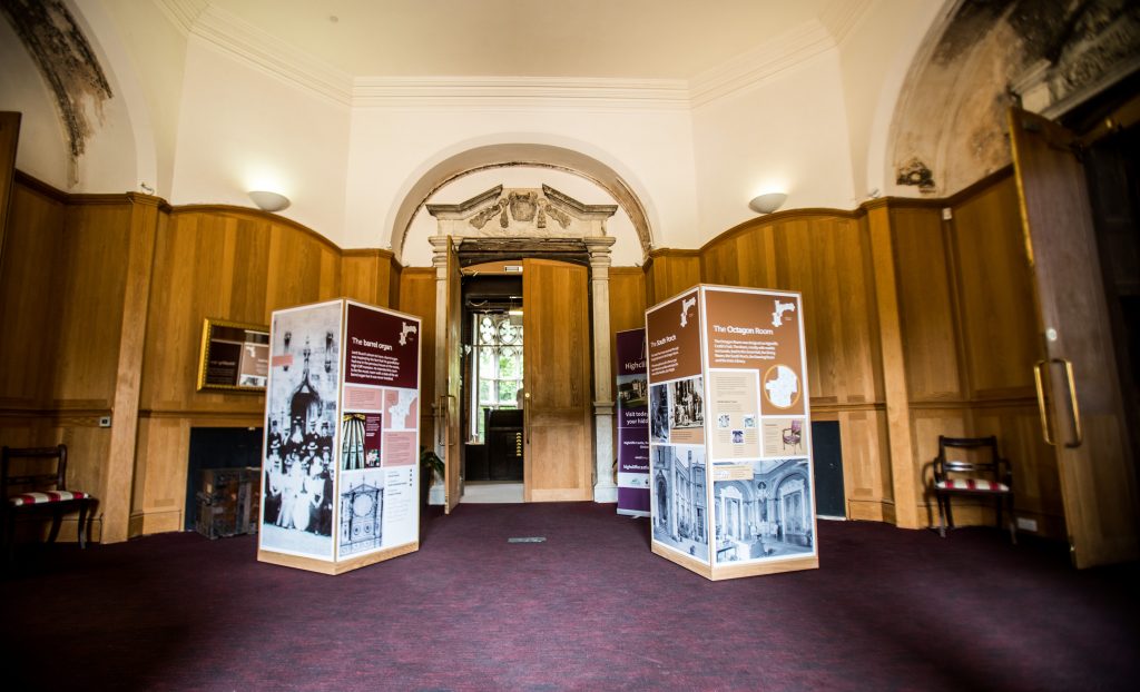 Wooden panelled room with two free standing, four sided floor displays.