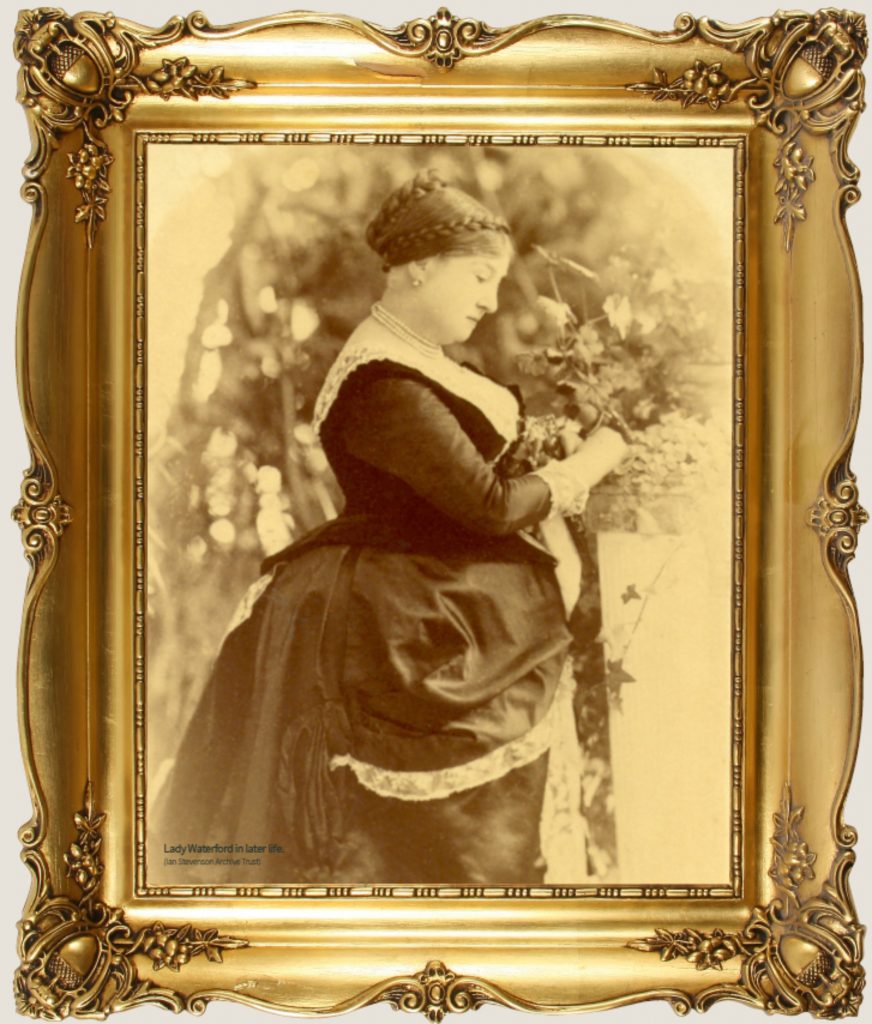 Sepia Portrait of Lady Waterford in long black dress with bustle and hair in a bun, in ornate gold frame