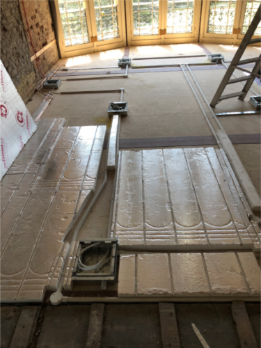 Shiny silver insulation panels laid over underfloor heating pipework