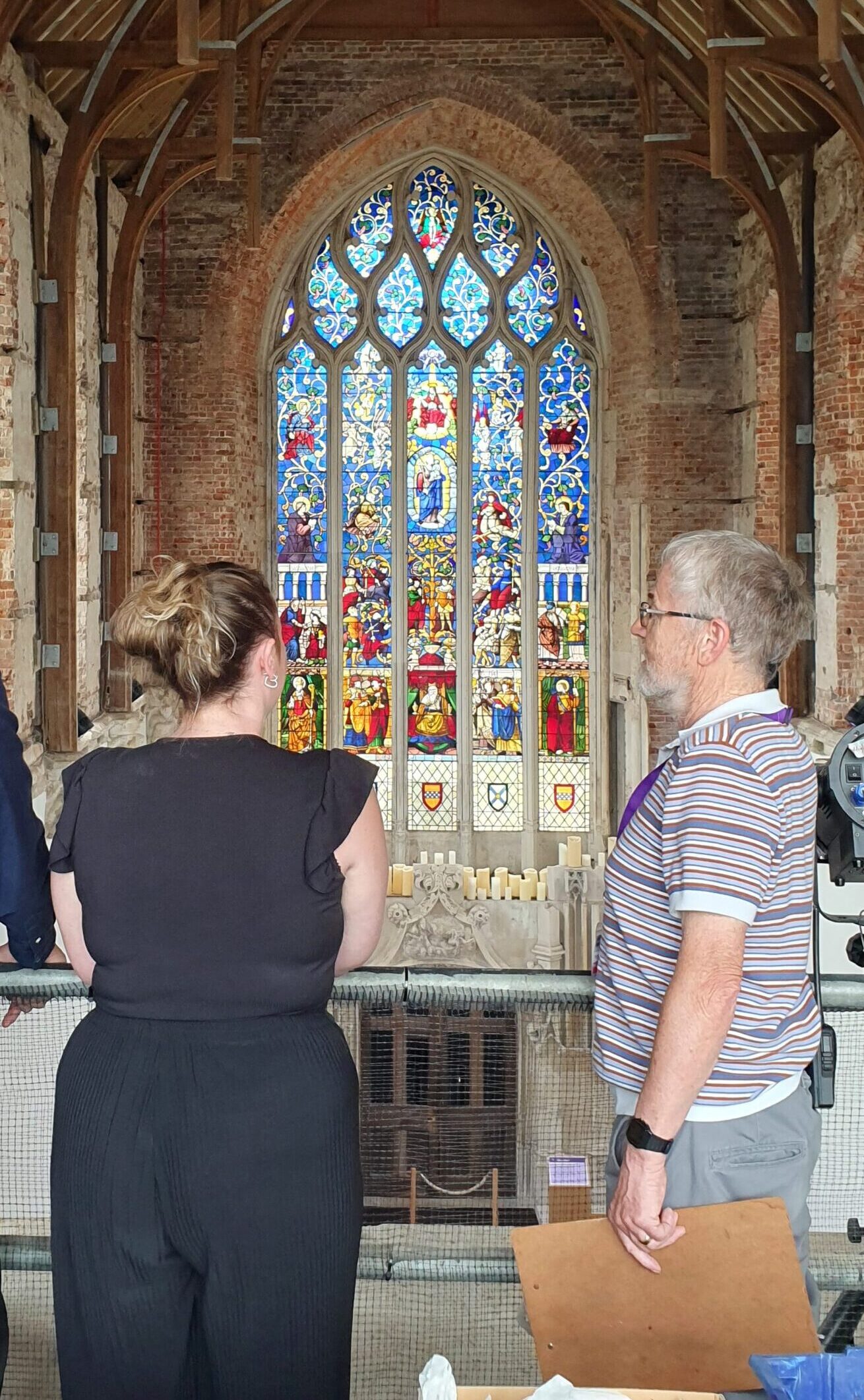 Tour guide in front of stained glass window with visitors